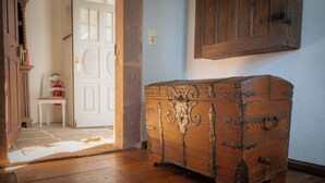 A wooden chest in a room with a white door and a blue wall.
