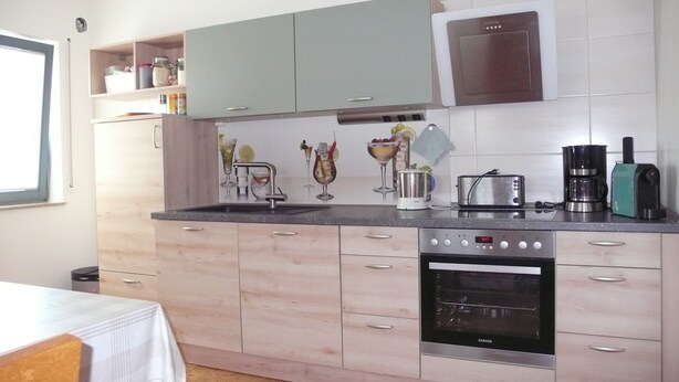 A kitchen with a built-in oven, a coffee maker, and a toaster.