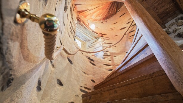 Techo de madera con diseño inclinado y una lámpara visible.
