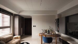 A modern living room with a sofa, a coffee table, and a dining area with a table and chairs. - Ximen Apartment by Olala Homes (Taipei)