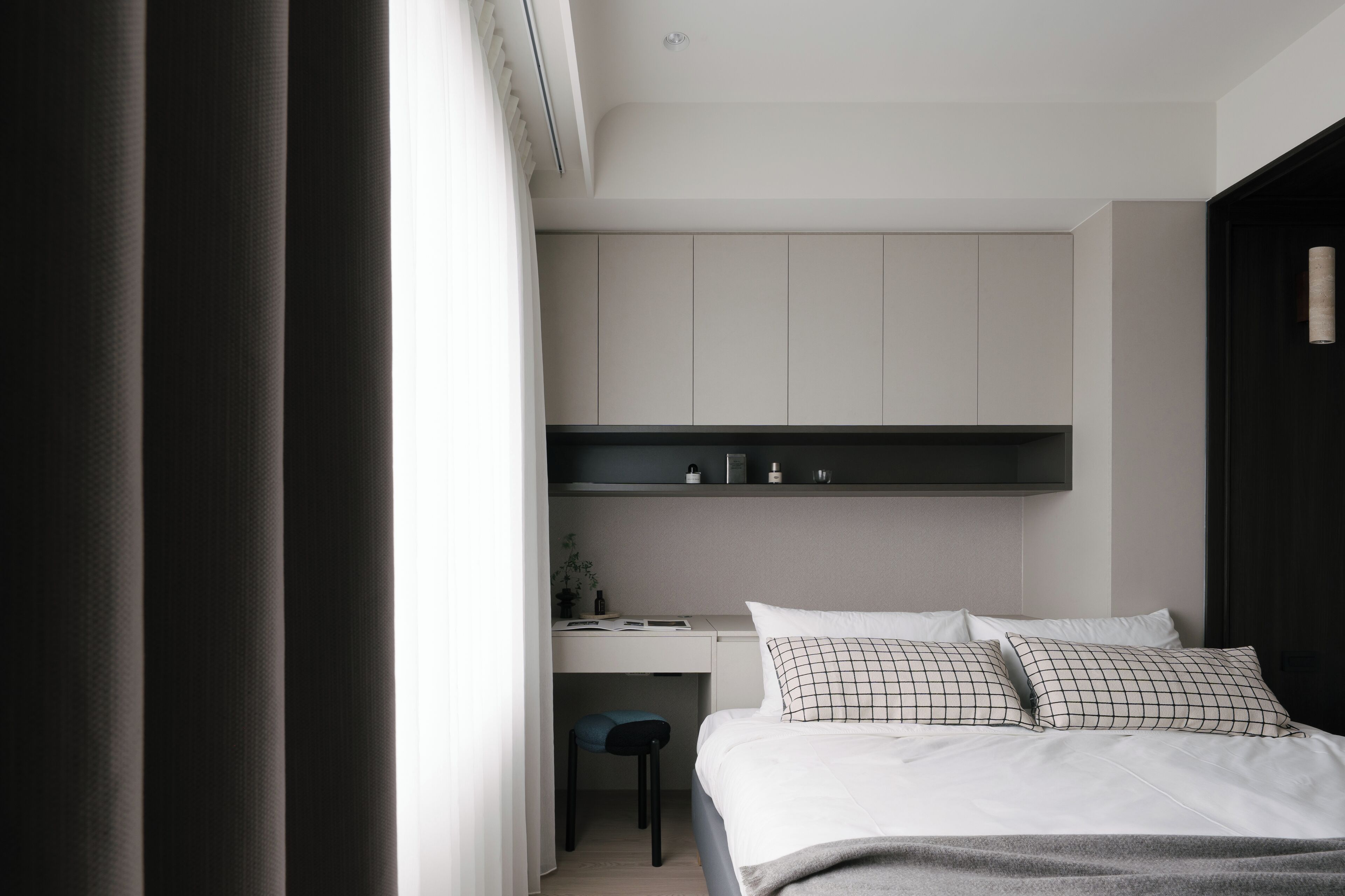 A modern bedroom with a bed, a desk, and a chair.