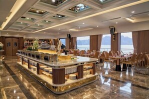 A spacious bar area with a marble countertop, seating for guests, and a view of the sea.