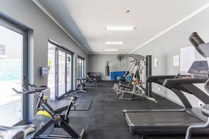 A gym with treadmills, weight machines, and a punching bag.