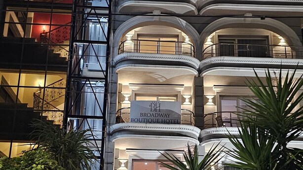 A multi-story hotel with a grand entrance, multiple balconies, and a well-lit facade. - Broadway Boutique Hotel (Tirana)