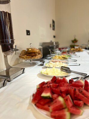 Une table de buffet proposant divers plats et un distributeur de café.
