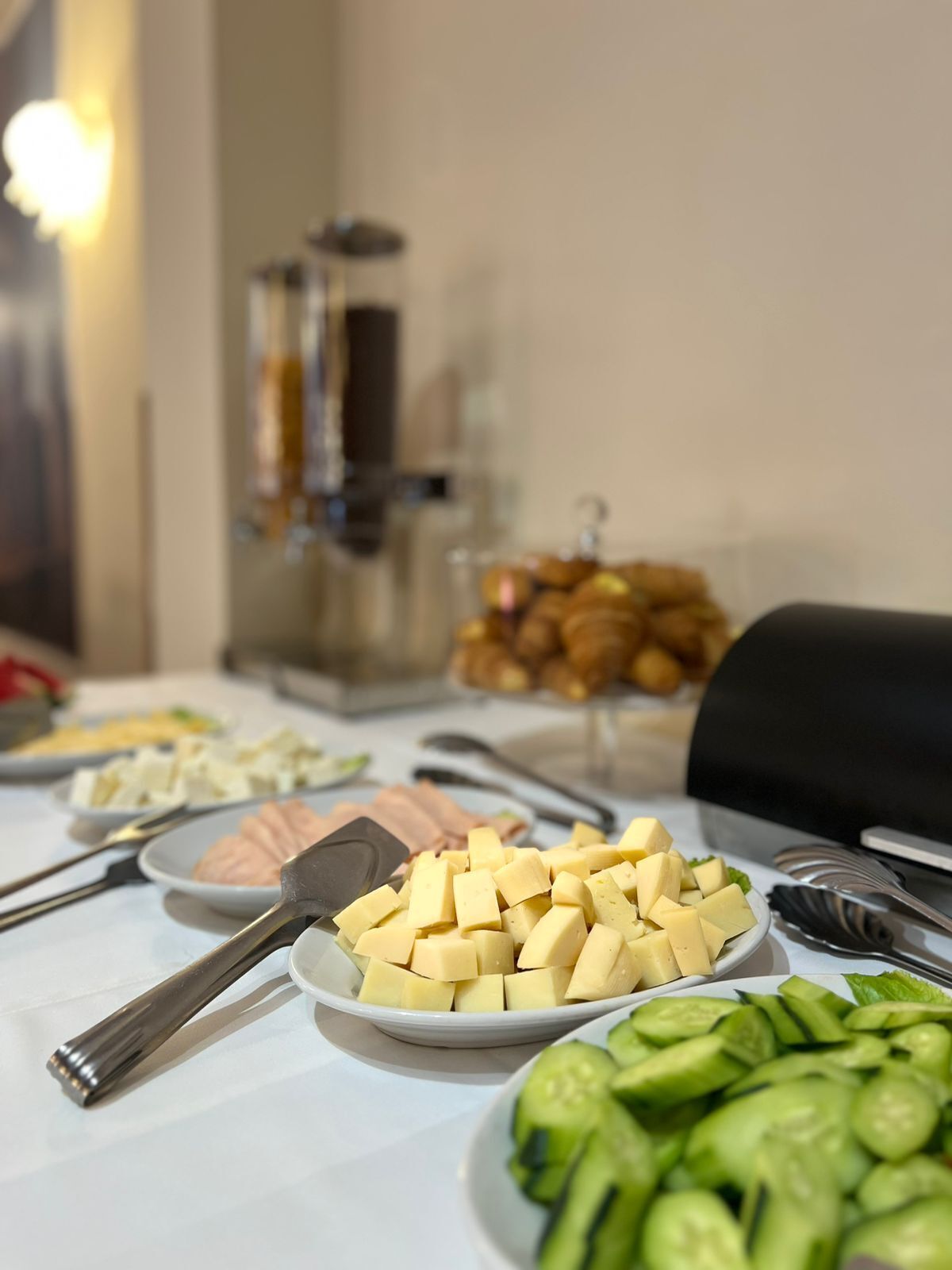 Een buffettafel met diverse gerechten, waaronder blokjes kaas, plakjes komkommer en andere maaltijden.