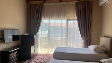 Chambre Quadruple Deluxe, balcon | Literie hypoallergénique, minibar, bureau, rideaux occultants