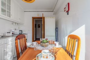 A kitchen with white cabinets, a microwave, and a dining table with chairs.