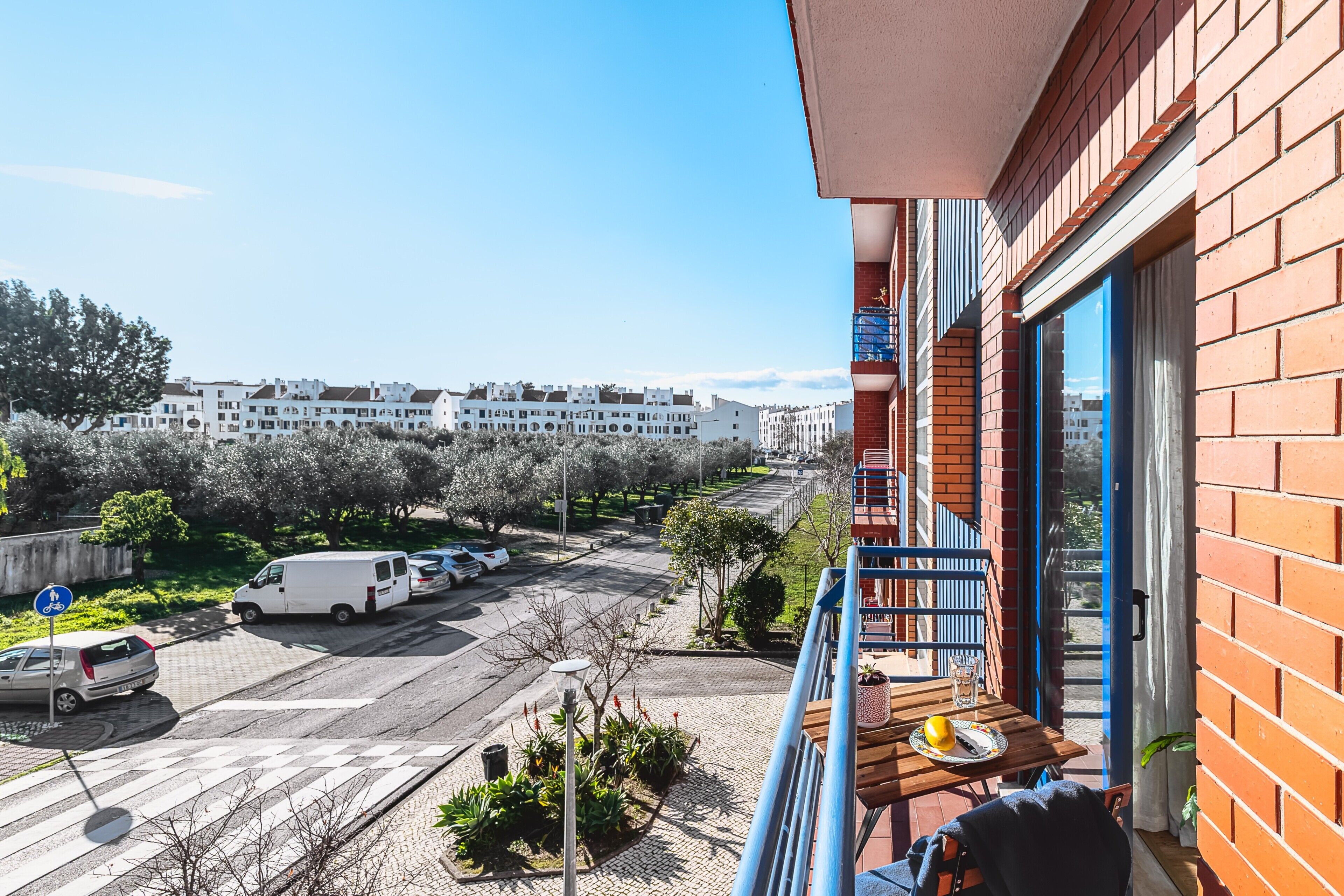 Ein Balkon mit Blick auf einen Parkplatz und Gebäude.
