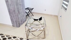 A room with a glass-top table and two chairs, a wooden door, and a tiled floor. - MarvelousStudio KingBed - 10minWalkToBorder (Tijuana)