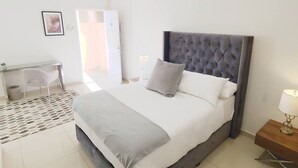 Un dormitorio moderno con una cama grande, un escritorio y una silla.