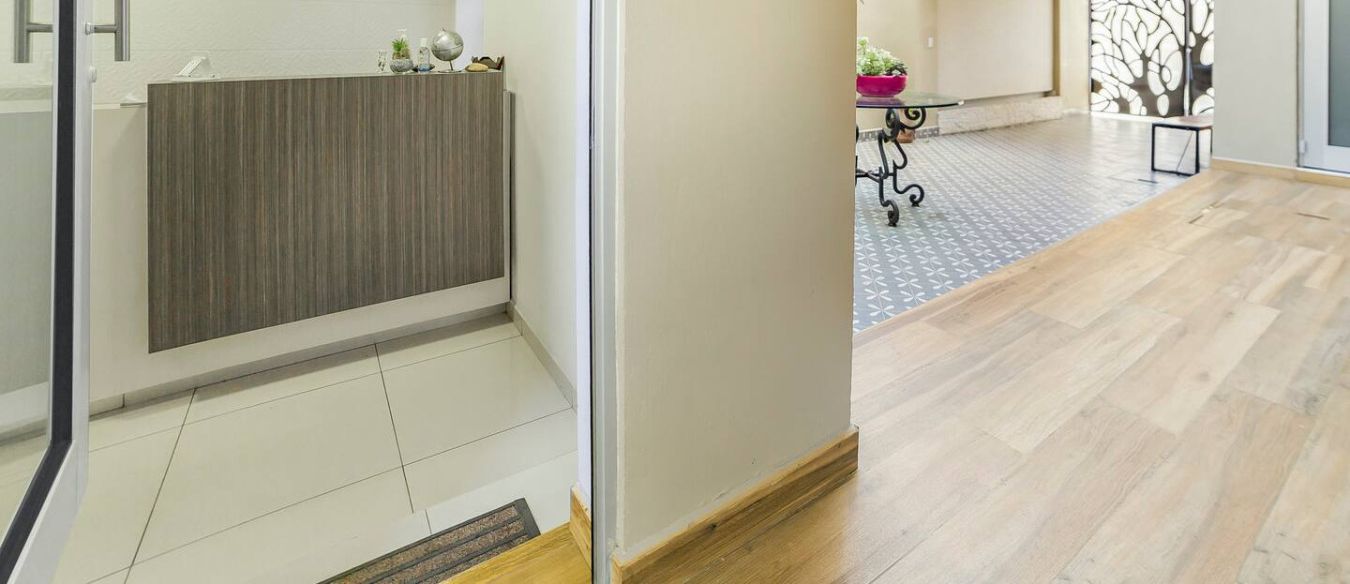 Un espace d’accueil comprenant un comptoir, une plante en pot et un mur décoratif.