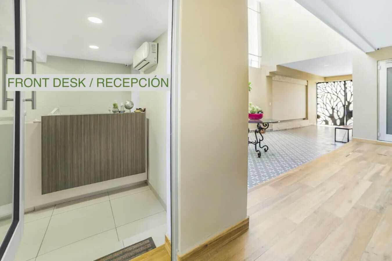 A reception area with a front desk, a wooden panel wall, and a tiled floor.