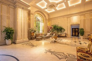 A grand lobby with a marble floor, a large staircase, and a reception desk. - Cozrum Homes - Sonata Residence (Ho Chi Minh City)