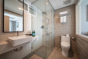 A modern bathroom with a glass shower enclosure, a white sink, and a toilet. - Cozrum Homes - Sonata Residence (Ho Chi Minh City)