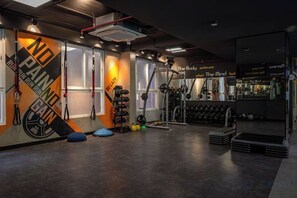 A gym with exercise equipment, a wall with motivational text, and a bar area. - Cozrum Homes - Sonata Residence (Ho Chi Minh City)