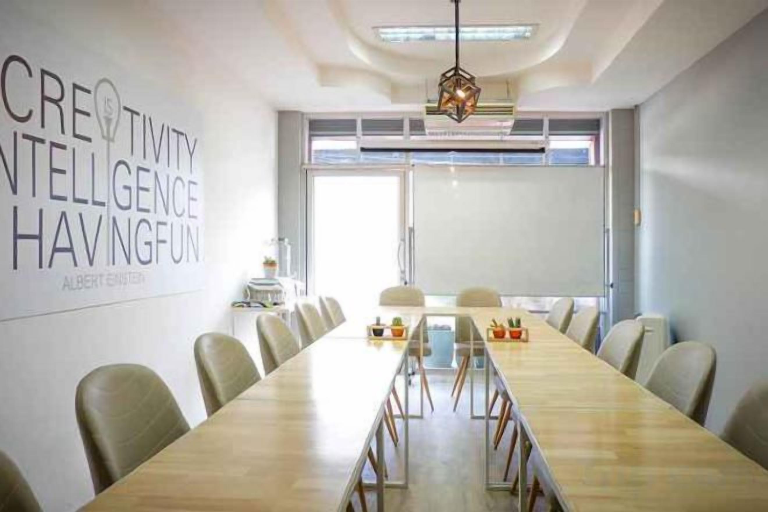 A conference room with a long table, chairs, and a large window.