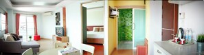 A hotel room with a bed, a TV, a dining area, and a bathroom. - Ingnaam Hotel (Rangsit)