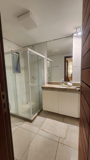 A modern bathroom with a glass shower enclosure, a large mirror, and a granite countertop. - CLUB MERIDIONAL CARNEIROS (Tamandaré)