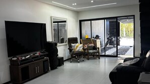 Un salon moderne avec un téléviseur à écran plat, un canapé et une table basse.