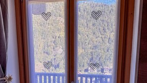 A wooden-framed door with two glass panels, each featuring a heart-shaped design at the top and bottom.