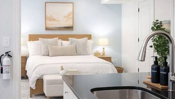 Une chambre d’hôtel avec un lit, une table de chevet, une lampe et une vue sur l’extérieur.