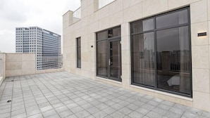 A building with large windows, a tiled floor, and a view of a high-rise building in the background. - Uiwang Milos Hotel (Uiwang-si)