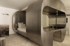 A modern, minimalist bedroom with a curved bed, a built-in desk, and a large mirror. - HIGHSTAY - Luxury Serviced Apartment - Saint-Germain (Paris)