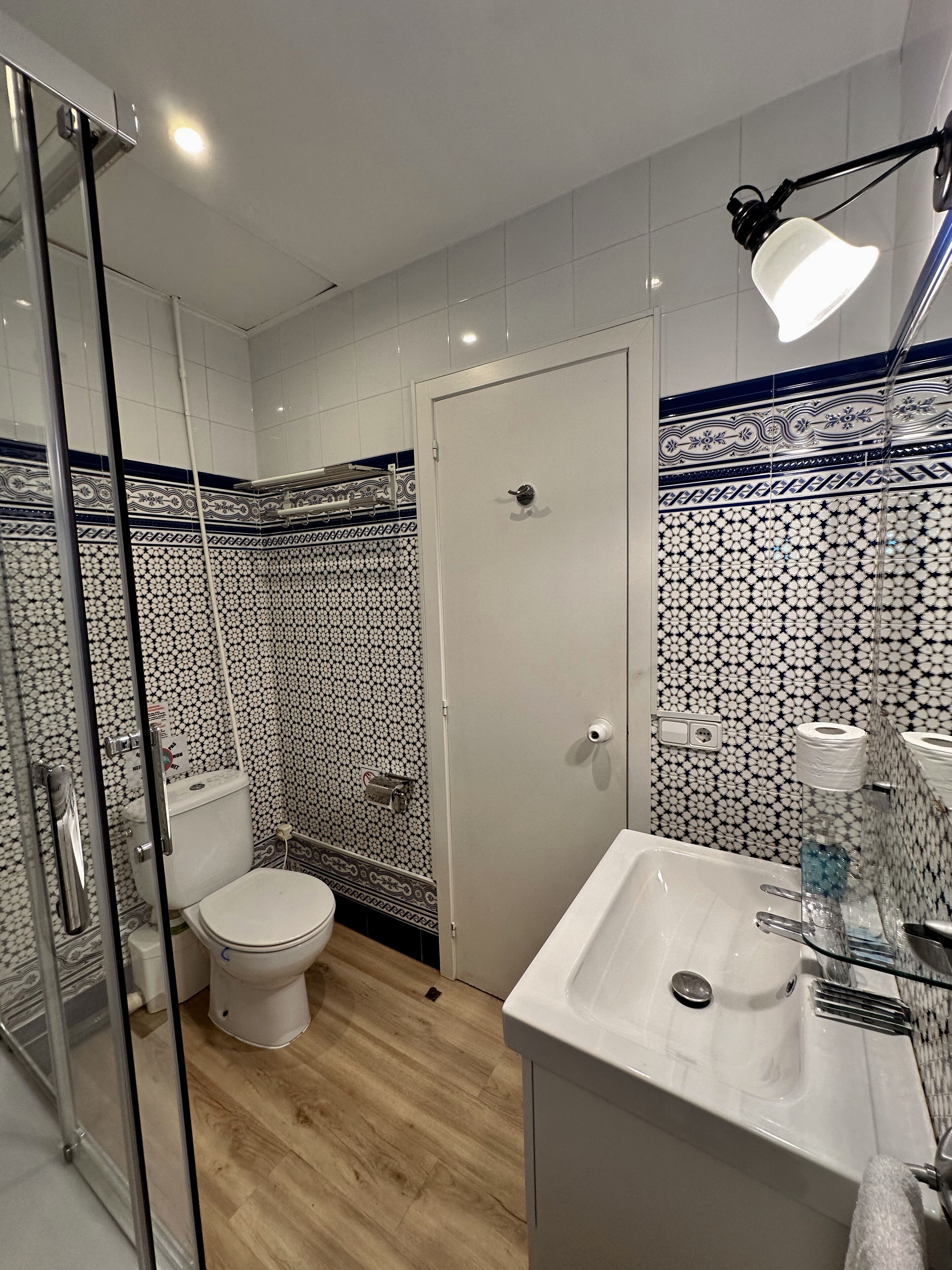 A bathroom with a toilet, a sink, and a shower area.