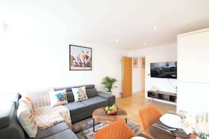 A modern living room with a sofa, coffee table, and TV.