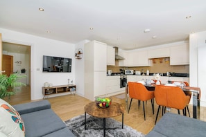 Un salon moderne comprenant un canapé, une table basse et un coin repas avec des chaises et une table.