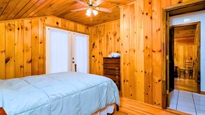 A wooden-paneled bedroom with a bed, a dresser, and a ceiling fan. - Private Ellijay Cabin Sleeps 6 - Loft, Stone Fireplace, Trails & Lake Nearby (Ellijay)