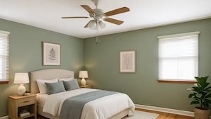 A bedroom with a bed, nightstands, a ceiling fan, and a potted plant. - Welcome to your perfect city retreat in the heart of Skokie! (Skokie)