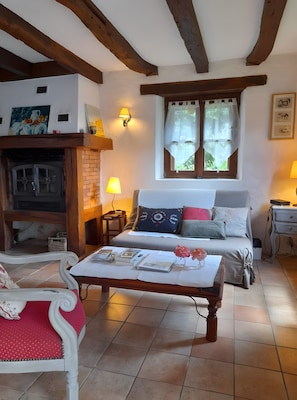 Uma sala de estar aconchegante com lareira, um sofá, uma mesa de centro e uma poltrona.