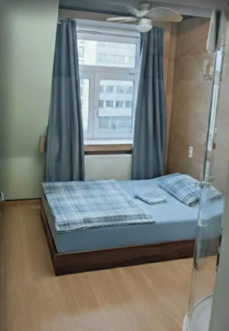 Un dormitorio con cama, cortinas y ventana.