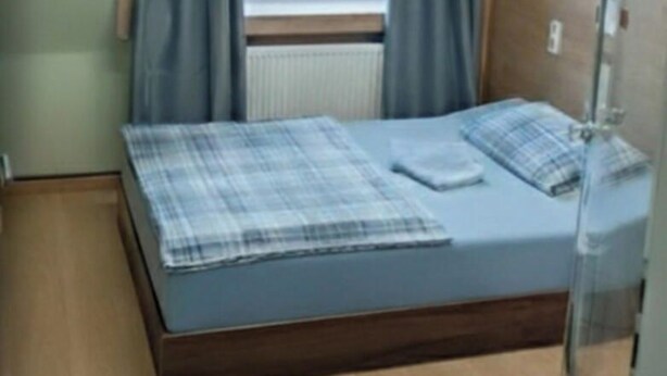 Une chambre à coucher avec un lit, des rideaux et une fenêtre.