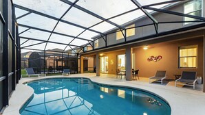 Ein Hallenbad mit Glasdecke, Liegestühlen und einem Essbereich.