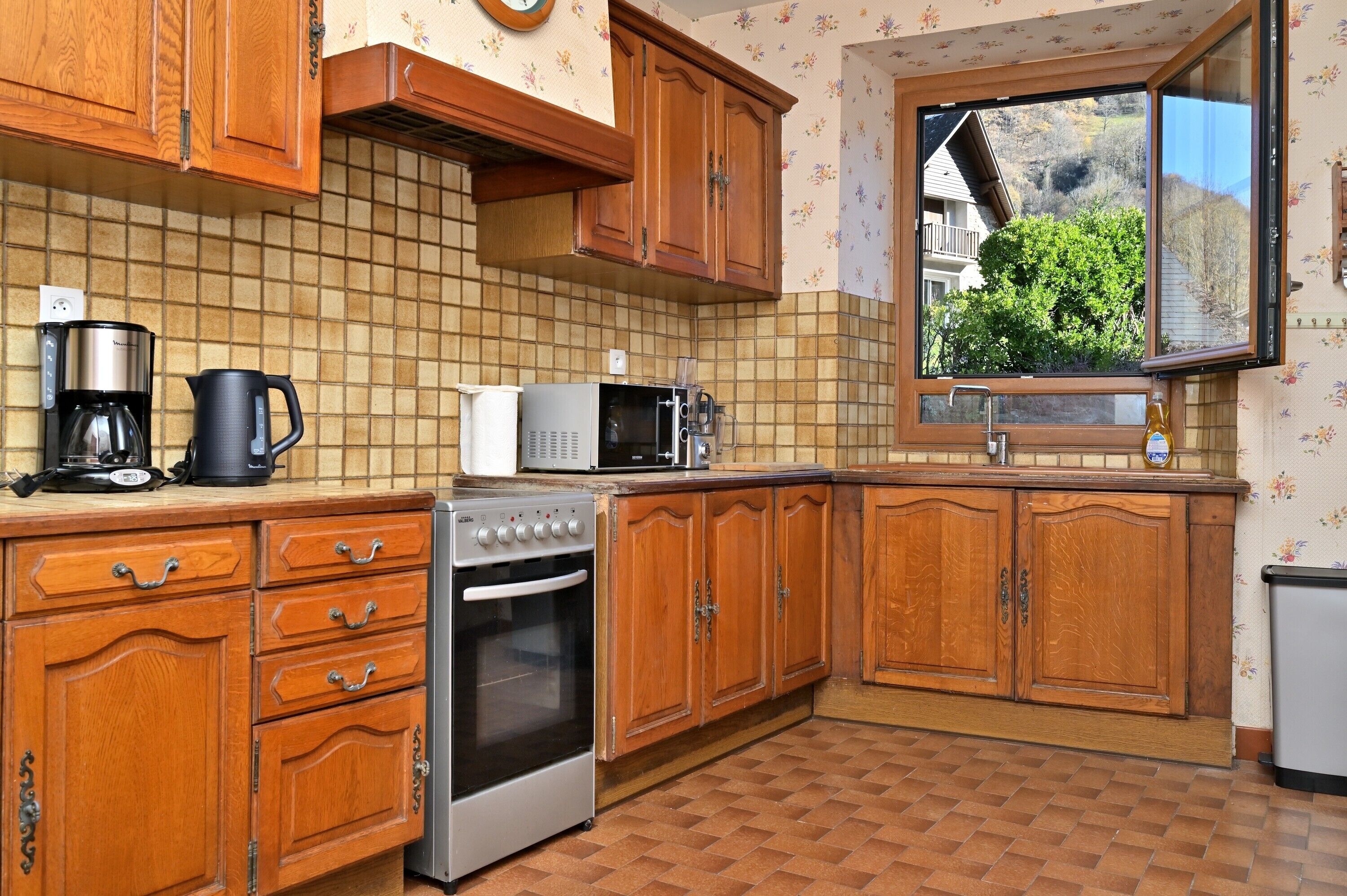 A kitchen with wooden cabinets, a microwave, a coffee maker, and a stove.