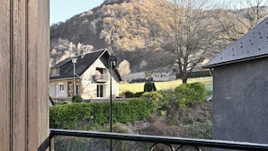 A house with a balcony, a mountain in the background, and a clear sky. - Holiday Home "Gîte à Cazaux - Bagnères de Luchon" with Private Garden (Cazaux-Layrisse)