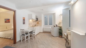 A compact apartment with a kitchenette, a dining area, and a bedroom. - Apartment 'Modern Flat in The Centre Of Genoa' with Wi-Fi and Air Conditioning (Genova)