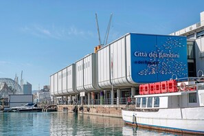 Ein Gebäude am Wasser mit einem Schild, auf dem 'Citta dei Bambini e dei Ragazzi' steht.