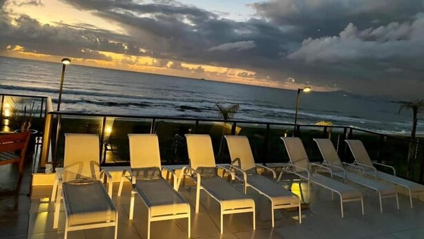 A deck with lounge chairs overlooking the ocean at sunset. - Feet in the sand - near Beto Carrero (Barra Velha)