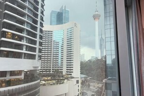 A high-rise building with a distinctive curved facade and a prominent 'R' on the side. - Summer Suites KLCC by Luna (Kuala Lumpur)