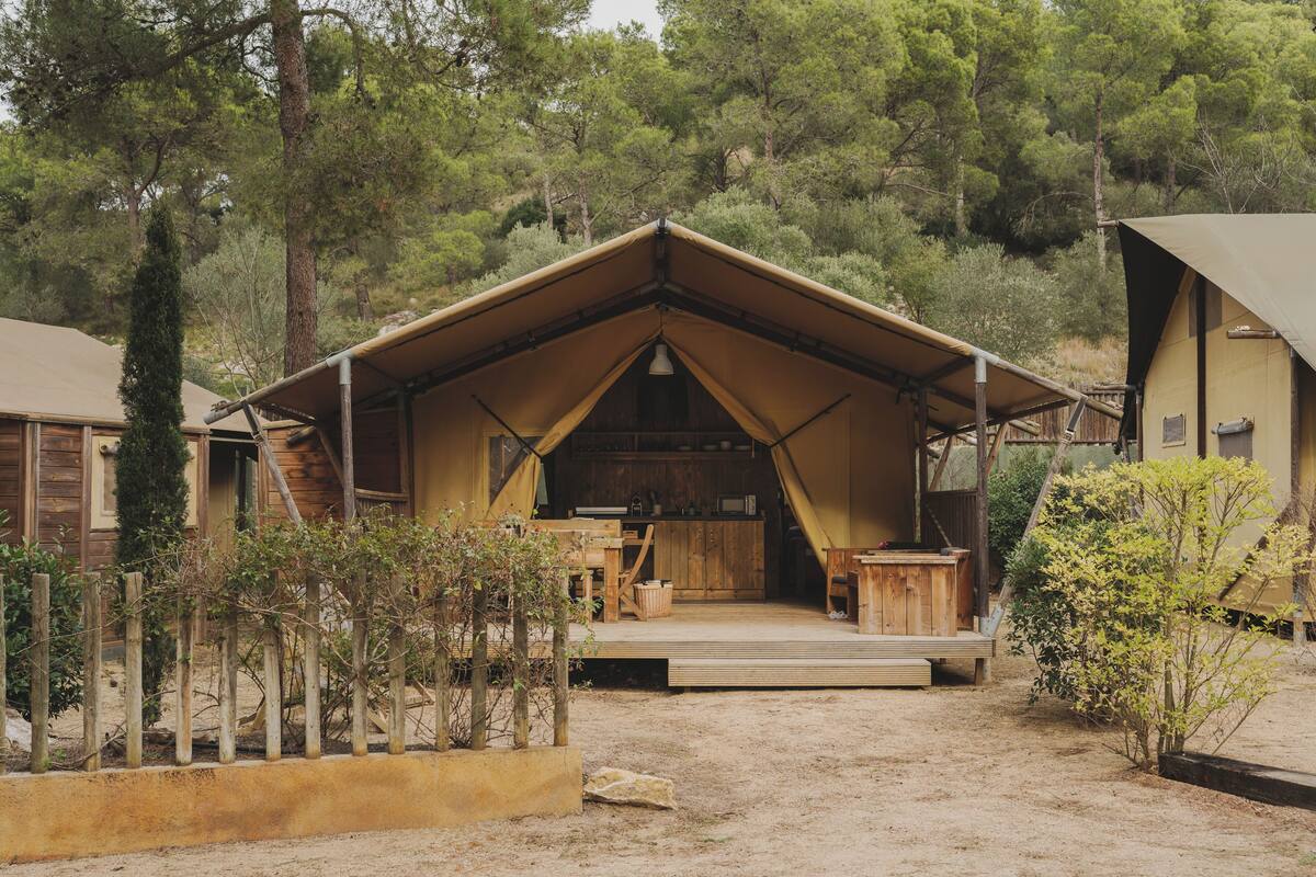 Une cabane rustique avec un toit en pente, un revêtement extérieur en bois et une véranda.