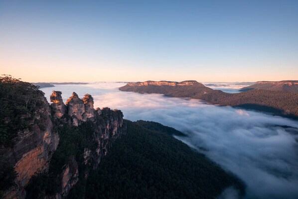 Un paysage montagneux caractérisé par d’imposantes formations rocheuses et une vallée en contrebas.