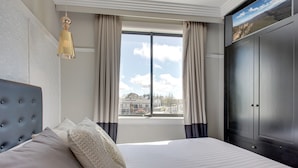 A hotel room with a large bed, a wardrobe, a window with curtains, and a hanging light fixture. - Perfect Located 2-bed Blue Mountains Getaway (Katoomba)