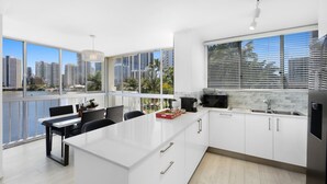 A modern kitchen with large windows, a dining area, and a view of the cityscape. - Stylish 2-bed in Surfers Paradise With River Views (Gold Coast)