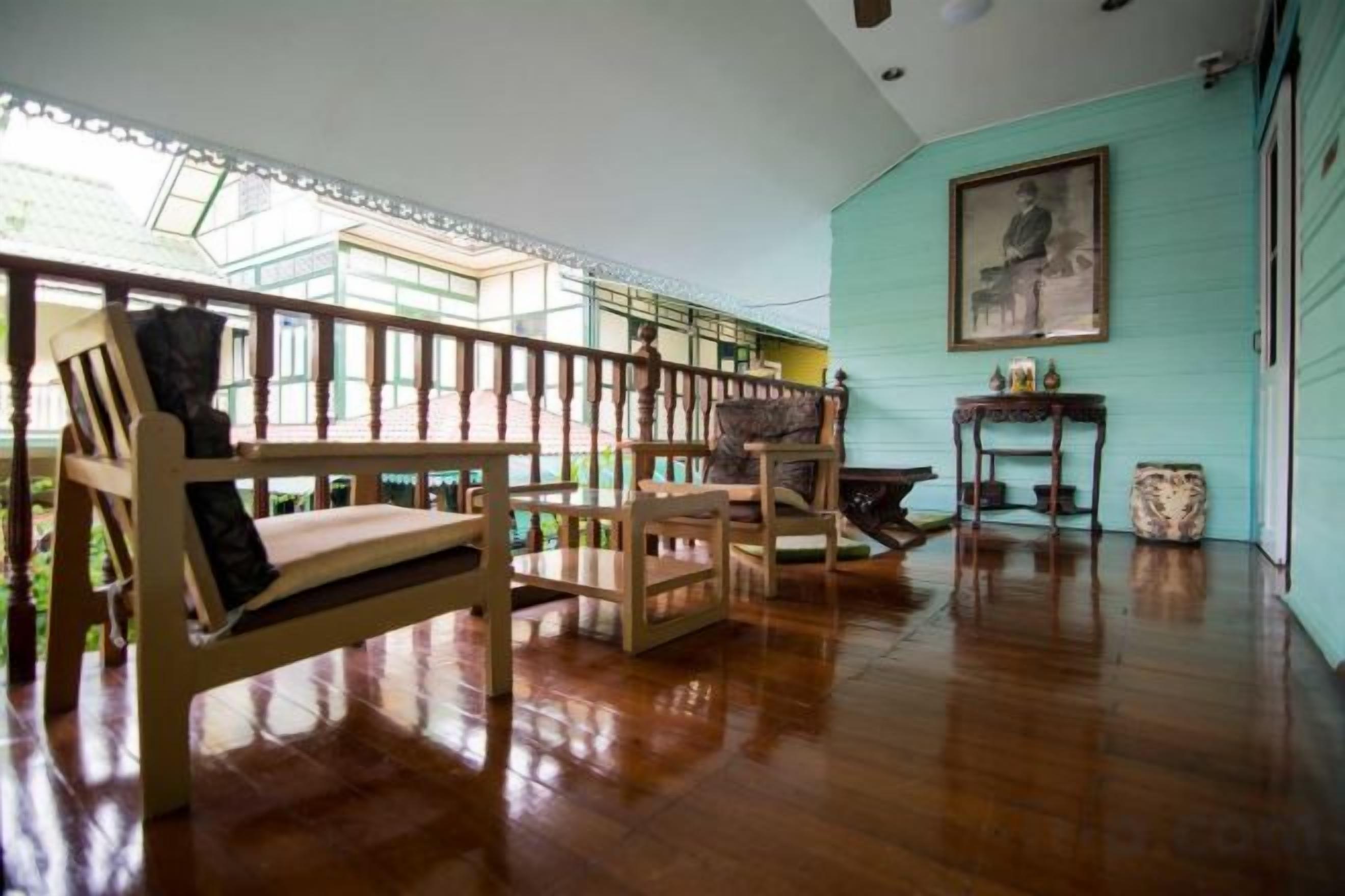 A spacious room with a wooden floor, a staircase, and a large window.