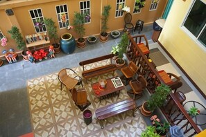 A courtyard with outdoor seating, potted plants, and a patterned floor. - Samsen Sam Place (Bangkok)