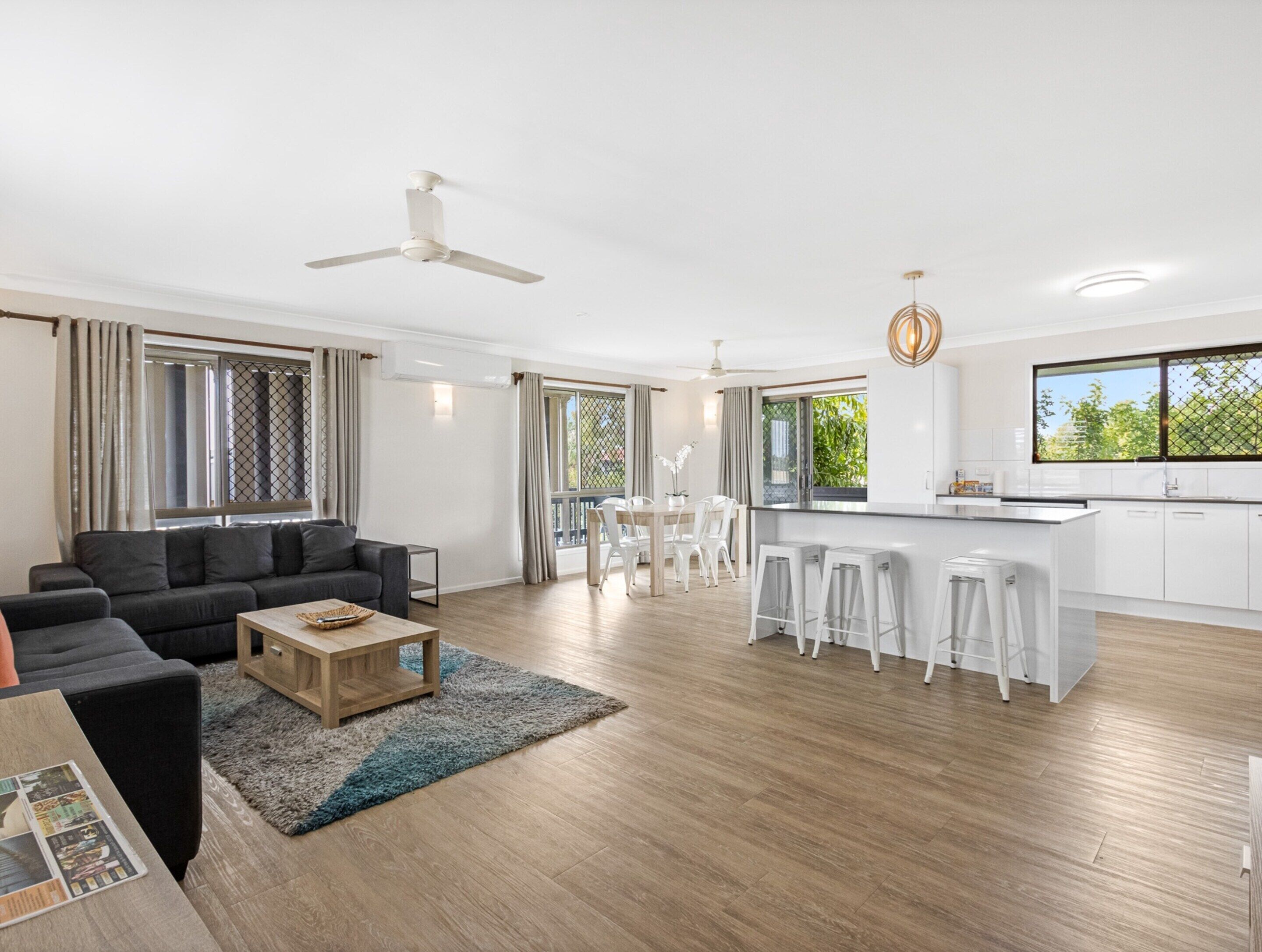 A spacious living area with a sofa, coffee table, and a dining set.